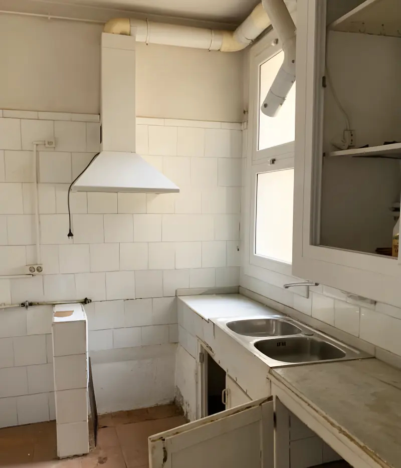 Cocina antigua con azulejo blanco, muebles de obra y campana vieja